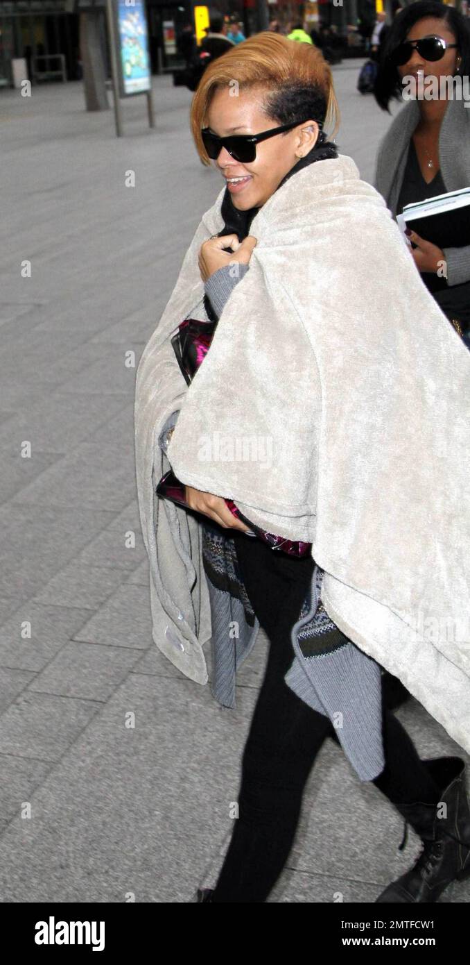 EXCLUSIF !! Rihanna avait l'air aussi confortable qu'un insecte, tout  enveloppé dans sa couverture chaude et confortable au départ de l'aéroport  de Londres Heathrow. Elle a laissé tous les sourires avec son