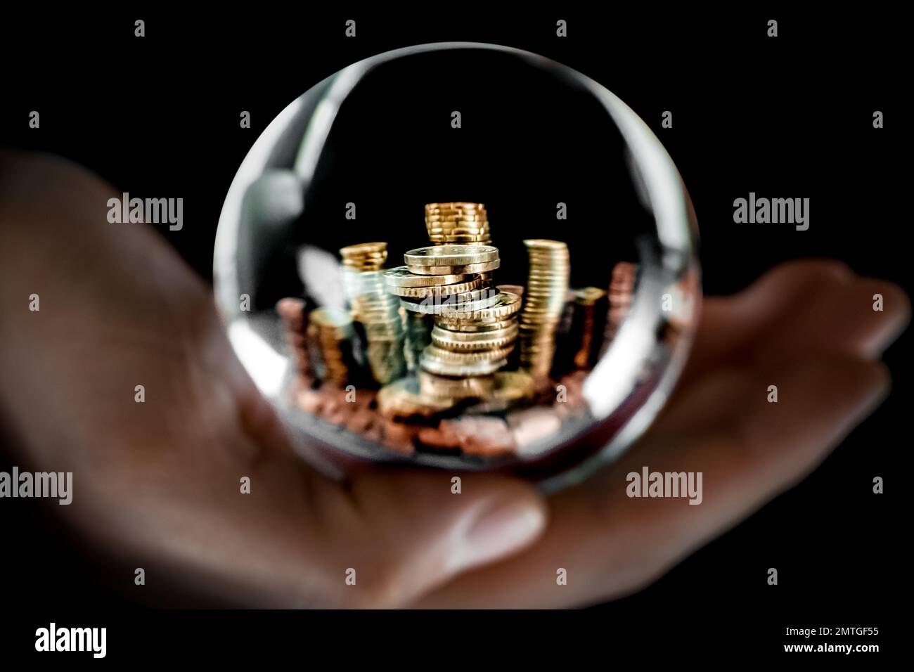 Image symbolique de plusieurs pièces de monnaie européennes métalliques empilées en piles avec un espace de copie sur le dessus, vue à travers une sphère de verre transparente. Banque D'Images