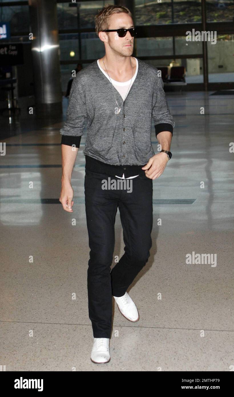 L'acteur Ryan Gosling est très élégant avec une paire de chaussures  blanches et un gilet gris lorsqu'il arrive au LAX après un vol au départ de  Cannes, en France. Gosling était dans