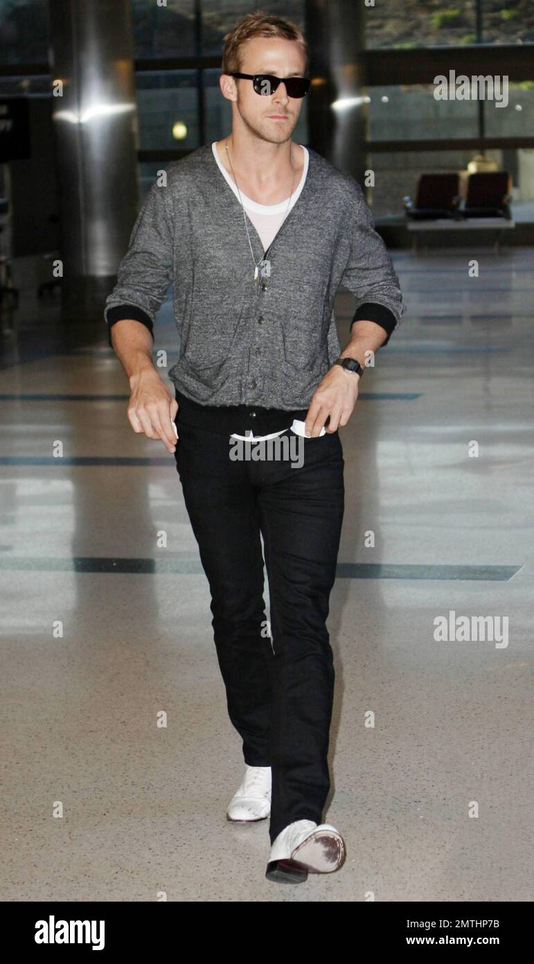 L'acteur Ryan Gosling est très élégant avec une paire de chaussures  blanches et un gilet gris lorsqu'il arrive au LAX après un vol au départ de  Cannes, en France. Gosling était dans