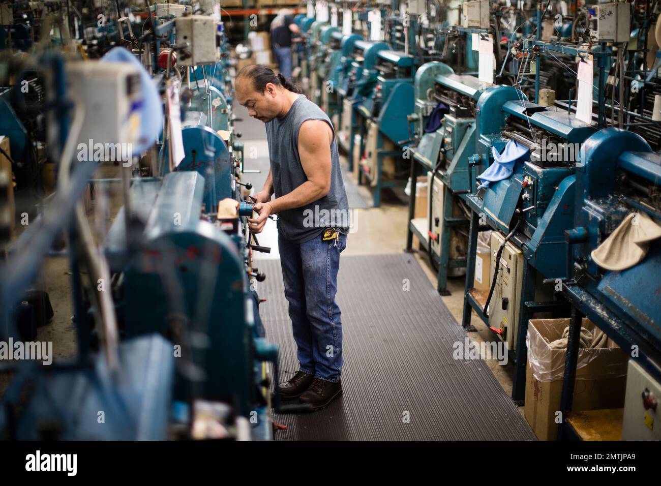 Hien Nguyen operates a knitting machine used in the manufacturing of