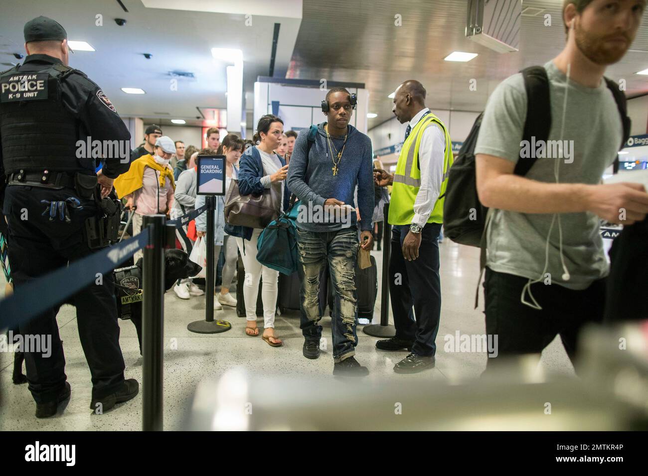 An Amtrak police officer with a bomb sniffing dog watches as people board a train en route to Boston at New York's Penn Station, as travelers set out for the long Memorial Day weekend, Friday, May 26, 2017. (AP Photo/Mary Altaffer) Banque D'Images