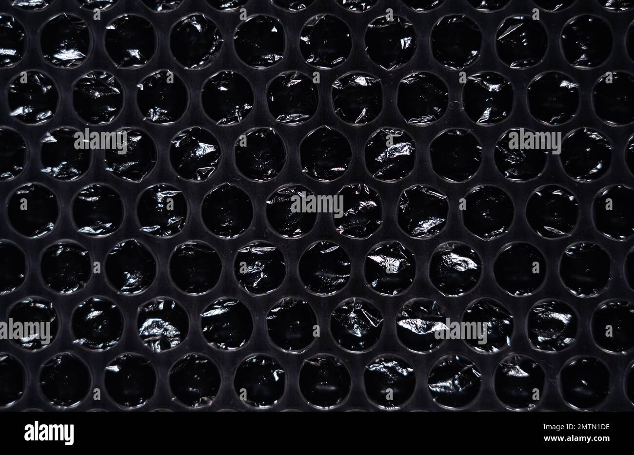 Texture de film à bulles sur fond noir. Le film protège la surface des impacts. polyéthylène. Banque D'Images