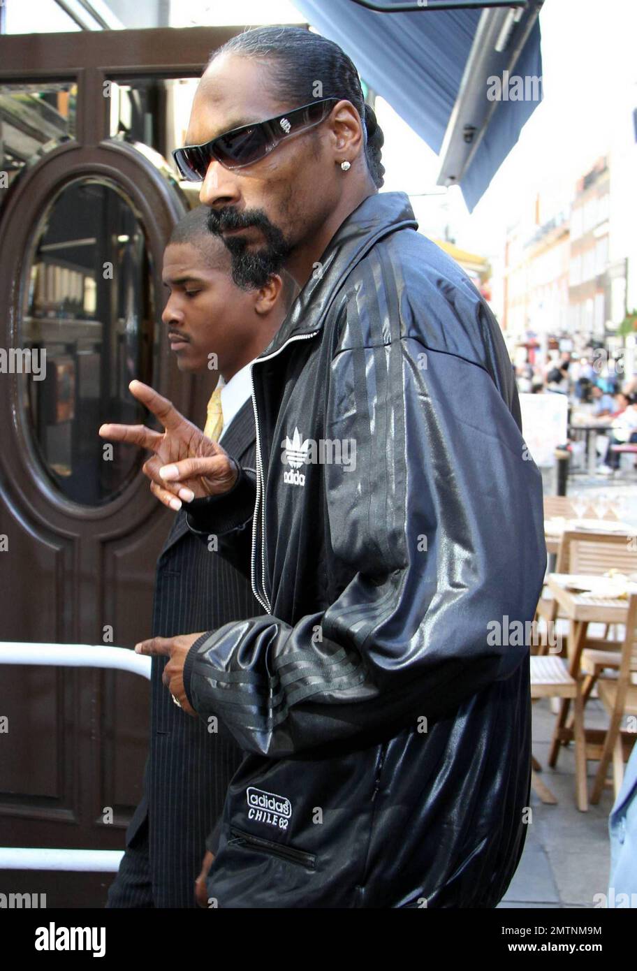 Portant un costume de piste Addidas noir, Snoop Dogg arrive dans un