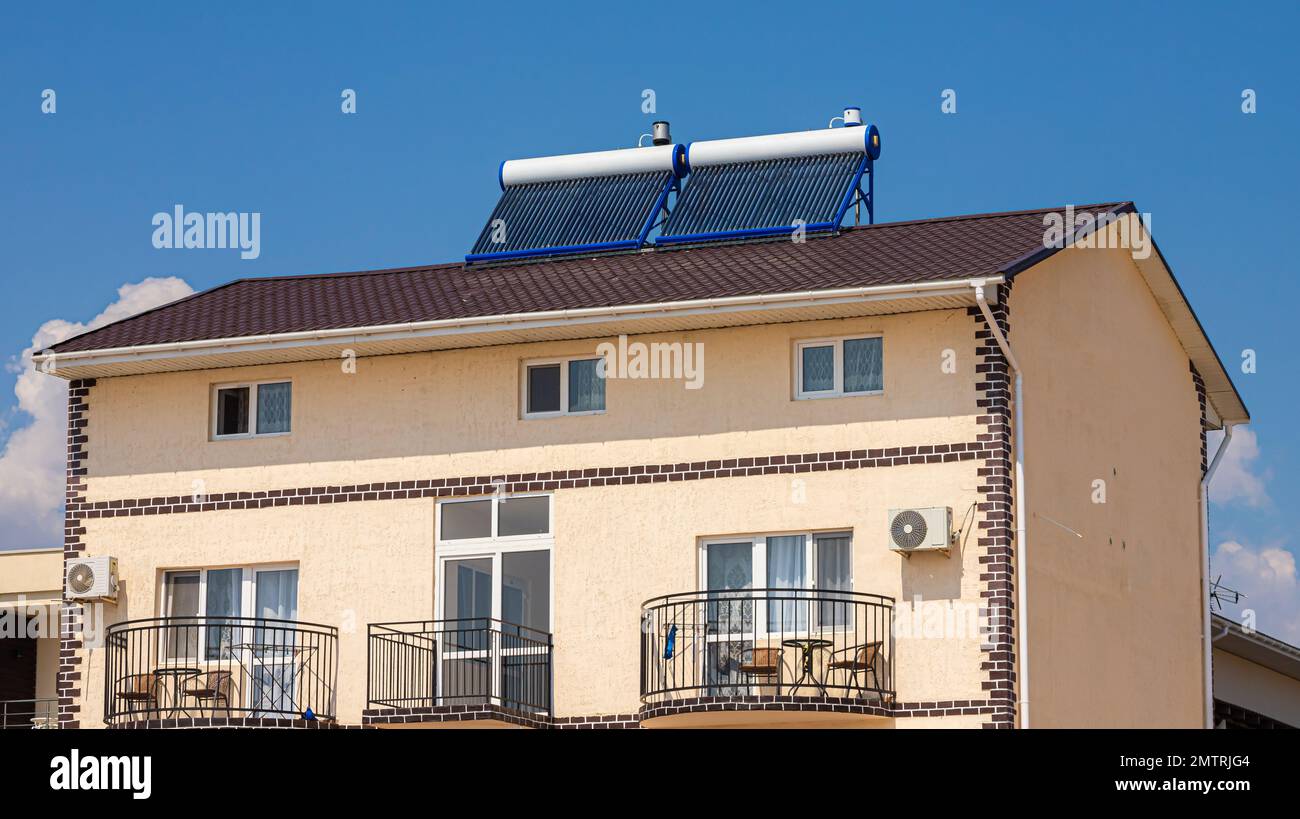Chauffe-eau solaire sur le toit, beau fond de ciel bleu. Banque D'Images