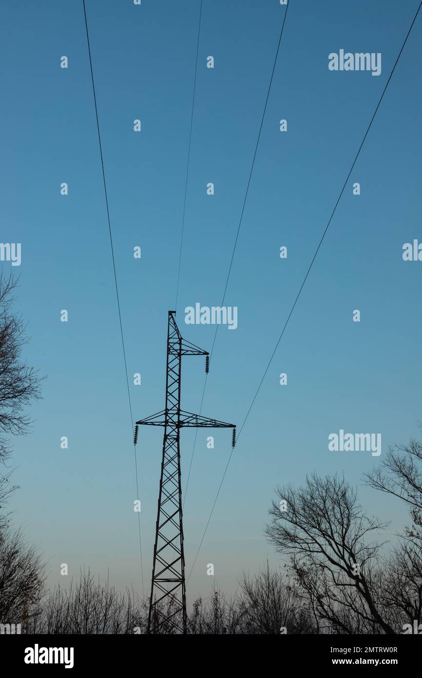 poteau de ligne électrique, dans la photo il y a un poteau de ligne électrique et des fils contre le ciel bleu. Banque D'Images