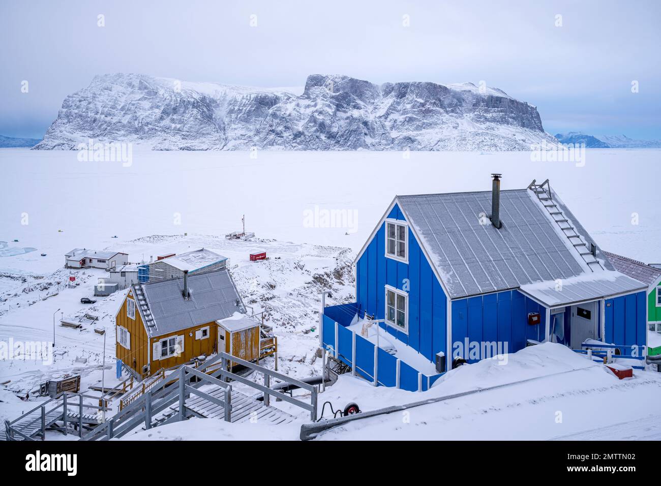 Maisons colorées accrochant sur le flanc de la montagne à Uummannaq dans l'ouest du Groenland Banque D'Images