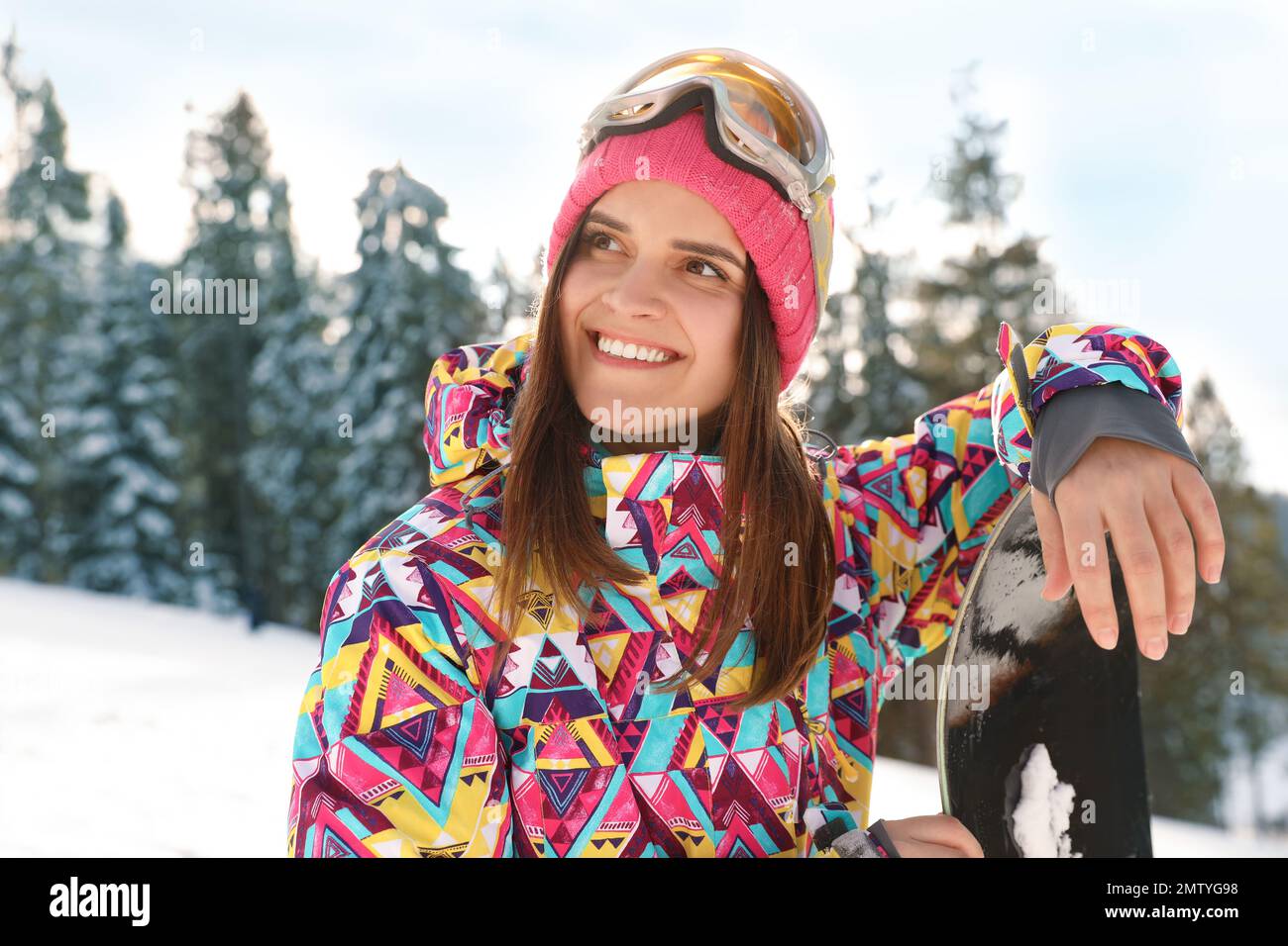 Jeune femme avec surf des neiges sur une pente enneigée. Vacances d'hiver Banque D'Images