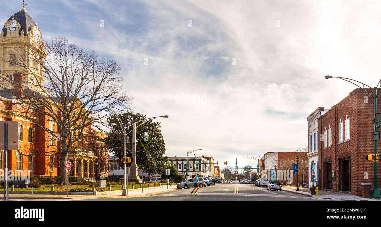 MONROE, NC, USA-28 JAN 2023: Vue grand angle sur main Street après court House vers la première église baptiste. Jour d'hiver ensoleillé. Chemin de table traversant Banque D'Images
