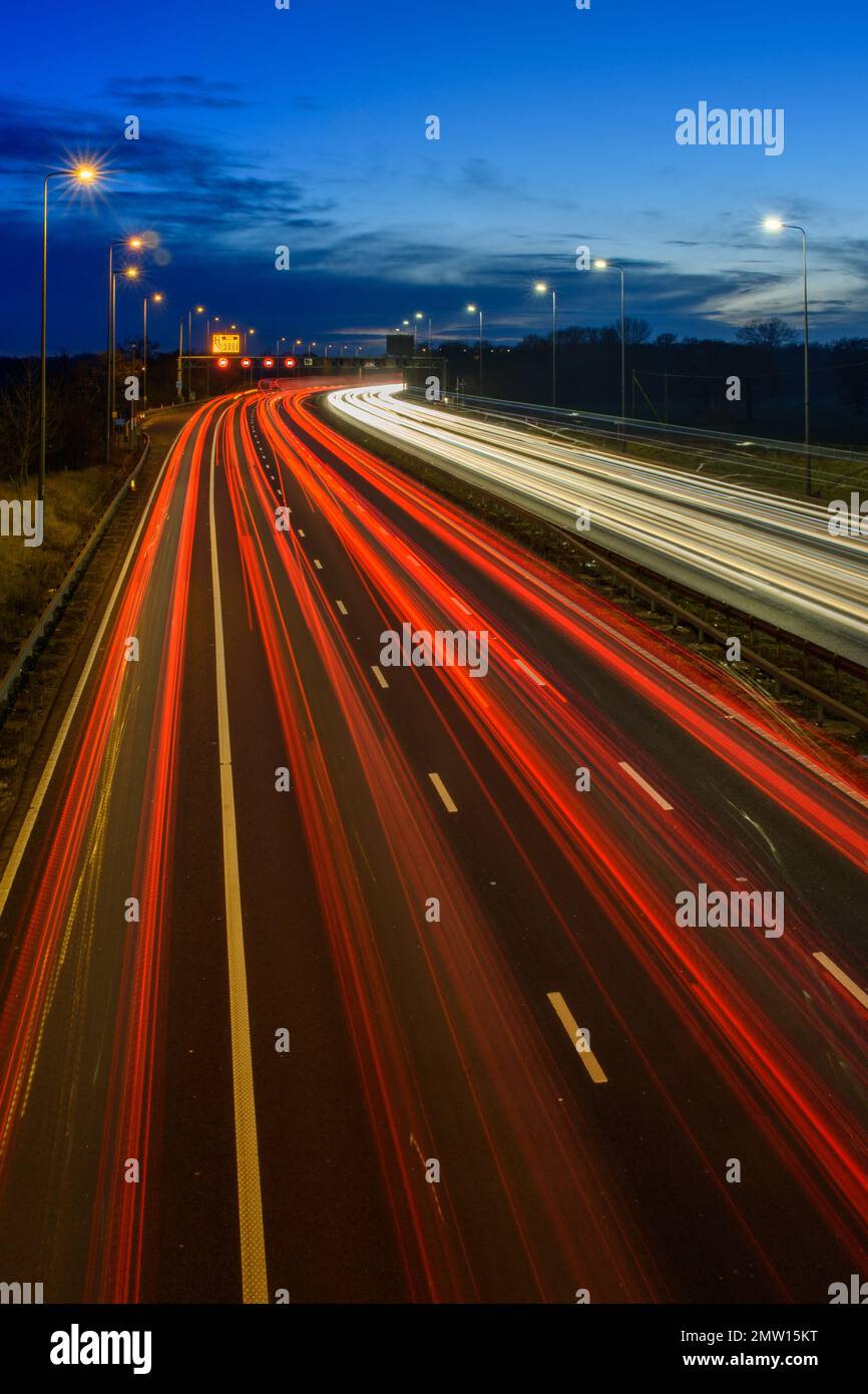 L'accélération de la circulation sur l'autoroute M42 pendant les heures de pointe du soir laisse des traces et des traînées de lumière dues à une vitesse d'obturation lente et à la photographie en exposition longue. Banque D'Images