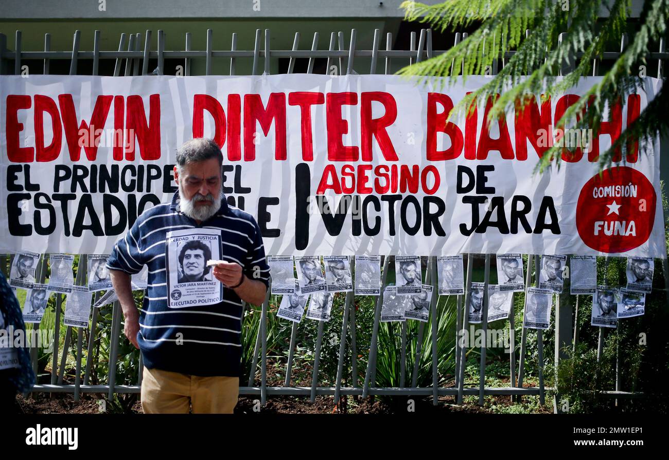 A man holds a portrait of Chilean songwriter Victor Jara outside the home of Edwin Dimter Bianchi, accused and on trial for the murder of Chilean singer-songwriter Victor Jara, during a demonstration to publicly shame him in Santiago, Chile, Saturday, April 22, 2017. The Funa Commission, which organized the protest, is a group of activists who aim to publicly denounce military and police officers who have gone unpunished for their alleged crimes committed during the country's military dictatorship, in an attempt to keep them from leading a normal life. (AP Photo/Esteban Felix) Banque D'Images