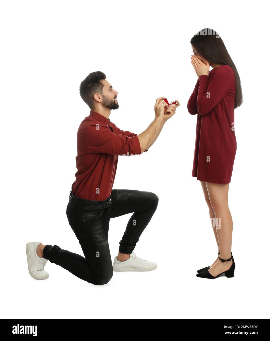 Homme avec bague d'engagement faisant la proposition de mariage à la petite amie sur fond blanc Banque D'Images