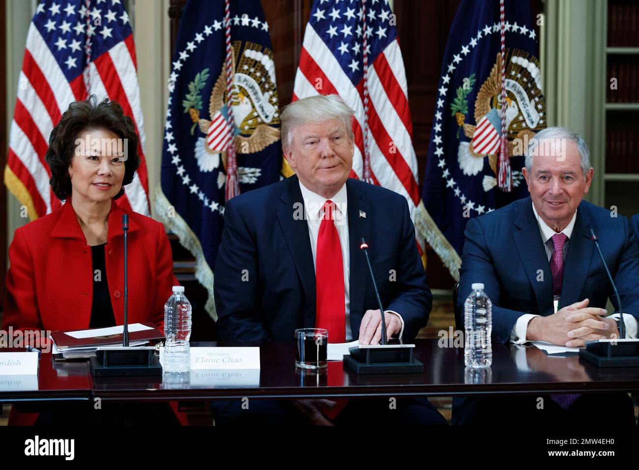 President Donald Trump , flanked by Transportation Secretary Elaine Chao, Trump, left, and Blackstone Group CEO Stephen Schwarzman, speaks during a meeting with business leaders in the State Department Library of the Eisenhower Executive Office Building on the White House complex in Washington, Tuesday, April 11, 2017. (AP Photo/Evan Vucci) Banque D'Images