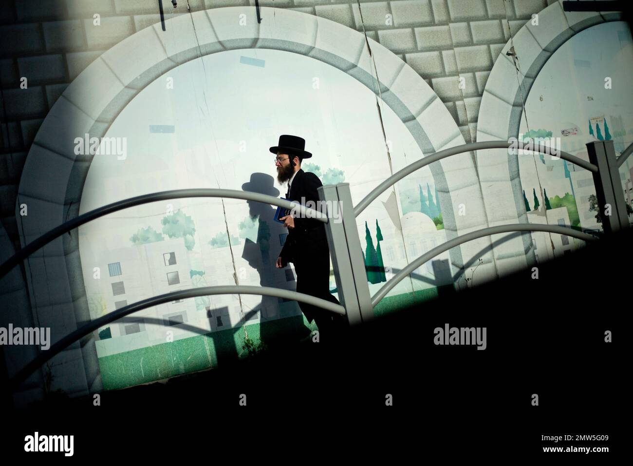 An ultra-Orthodox Jewish man carries a holy book as he prepares to collect water from a well to be used in the preparation of matzo, a traditional handmade Passover unleavened bread, in the ultra-Orthodox Jewish town of Bnei Brak, near Tel Aviv, Israel, Wednesday, April 5, 2017. Jews are forbidden to eat leavened foodstuffs during the Passover holiday that celebrates the biblical story of the Israelites' escape from slavery and exodus from Egypt. (AP Photo/Ariel Schalit) Banque D'Images