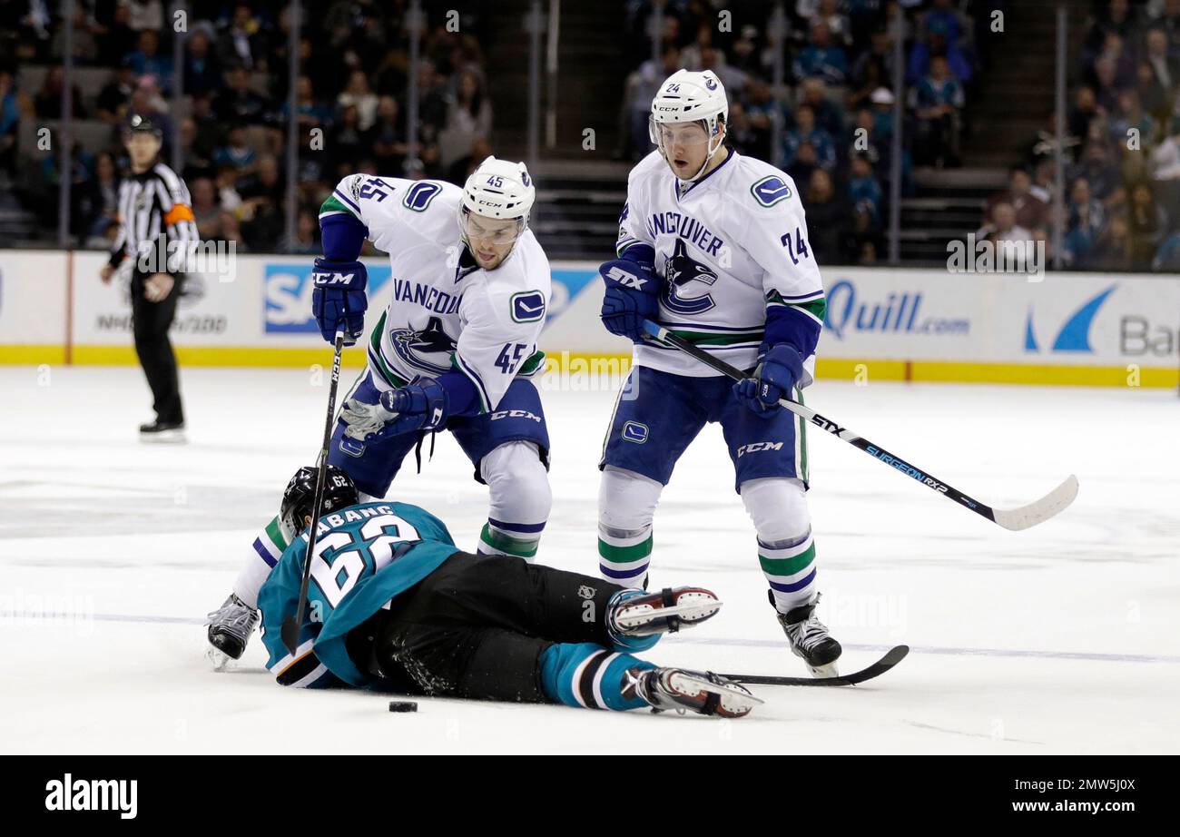 San Jose Sharks right wing Kevin Labanc, bottom, collides with Vancouver Canucks' Michael Chaput (45) and Reid Boucher (24) during the first period of an NHL hockey game Tuesday, April 4, 2017, in San Jose, Calif. (AP Photo/Marcio Jose Sanchez) Banque D'Images