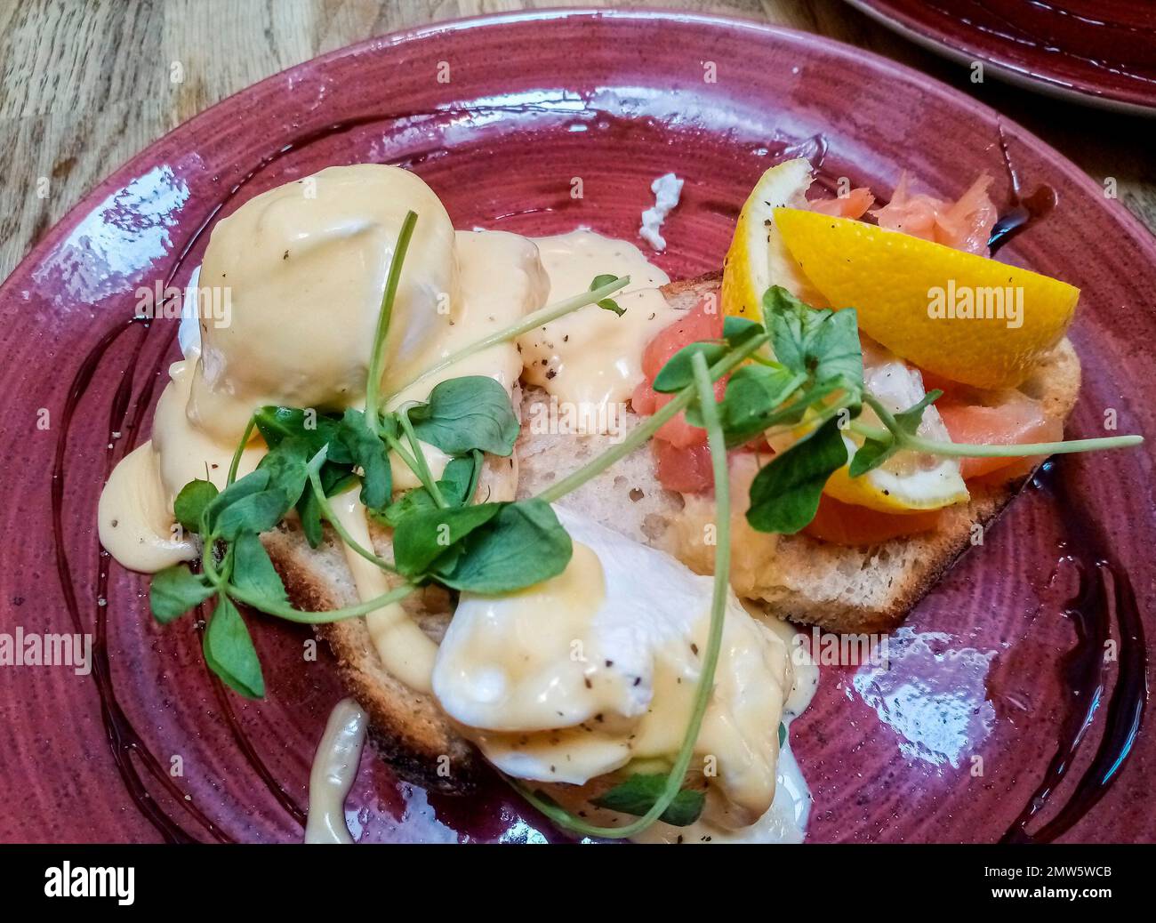 Vue de dessus des œufs pochés avec sauce et saumon sur le pain grillé. Banque D'Images