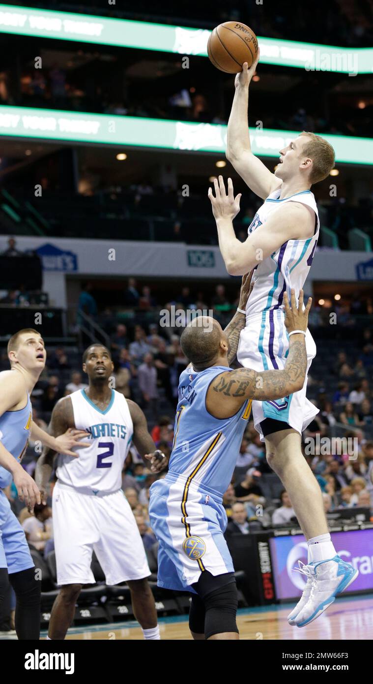Charlotte Hornets' Cody Zeller, right, shoots over Denver Nuggets' Jameer Nelson, left, in the first half of an NBA basketball game in Charlotte, N.C., Friday, March 31, 2017. (AP Photo/Chuck Burton) Banque D'Images