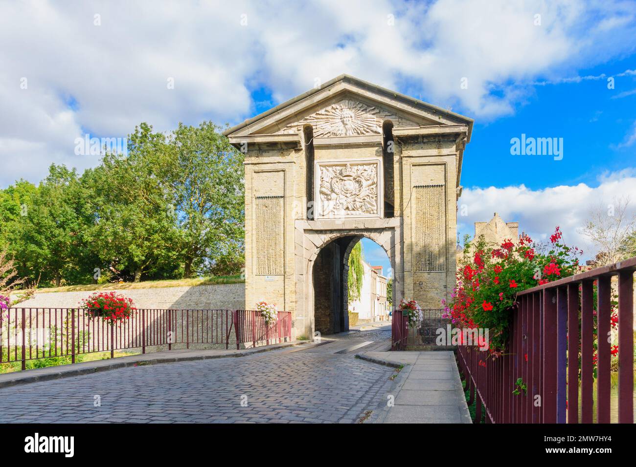 Vue sur la porte de Cassel, incorporant le soleil rayonnant de Louis XIV, à Bergues, dans le nord de la France Banque D'Images