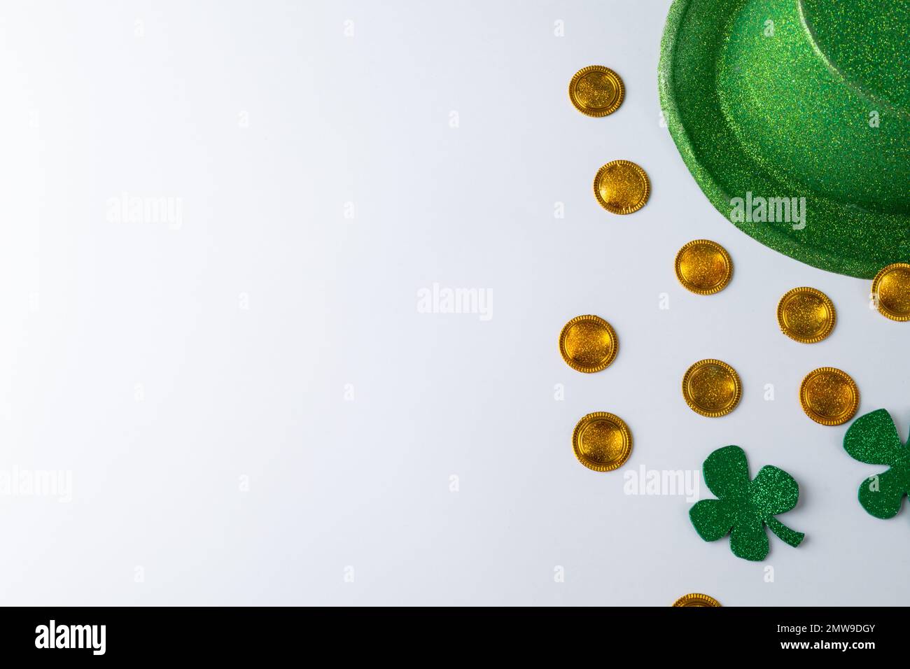 Chapeau vert, pièces de monnaie dorées et décorations de shamrock avec espace de copie sur fond blanc Banque D'Images