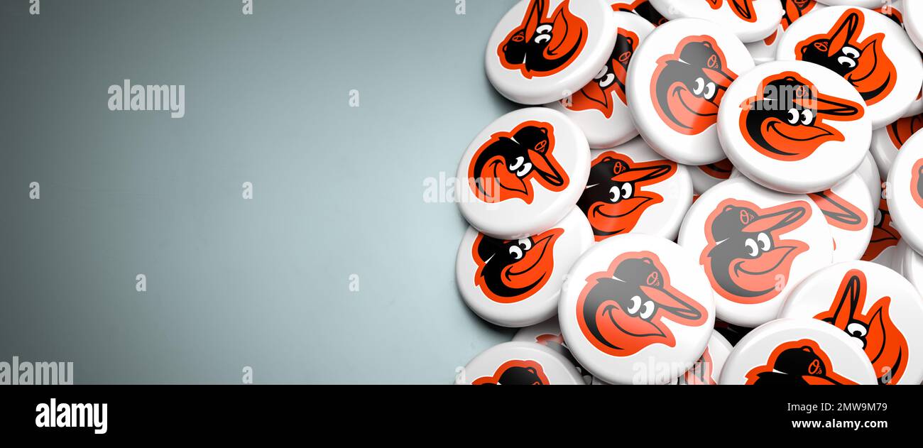 Logos de l'équipe de baseball de la Ligue majeure américaine Baltimore Orioles sur un tas sur une table. Banque D'Images