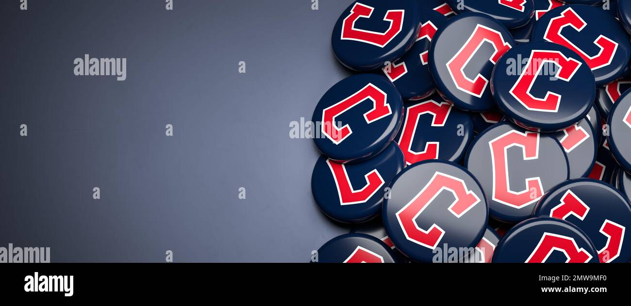 Logos de l'équipe américaine de baseball de la Ligue majeure Cleveland Guardians sur un tas sur une table. Banque D'Images