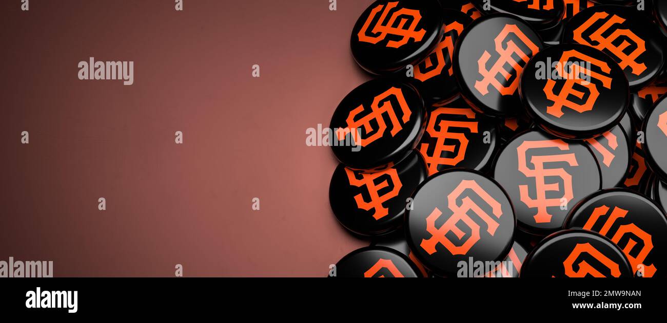 Logos de l'équipe de baseball de la Ligue majeure américaine San Francisco Giants sur un tas sur une table. Banque D'Images