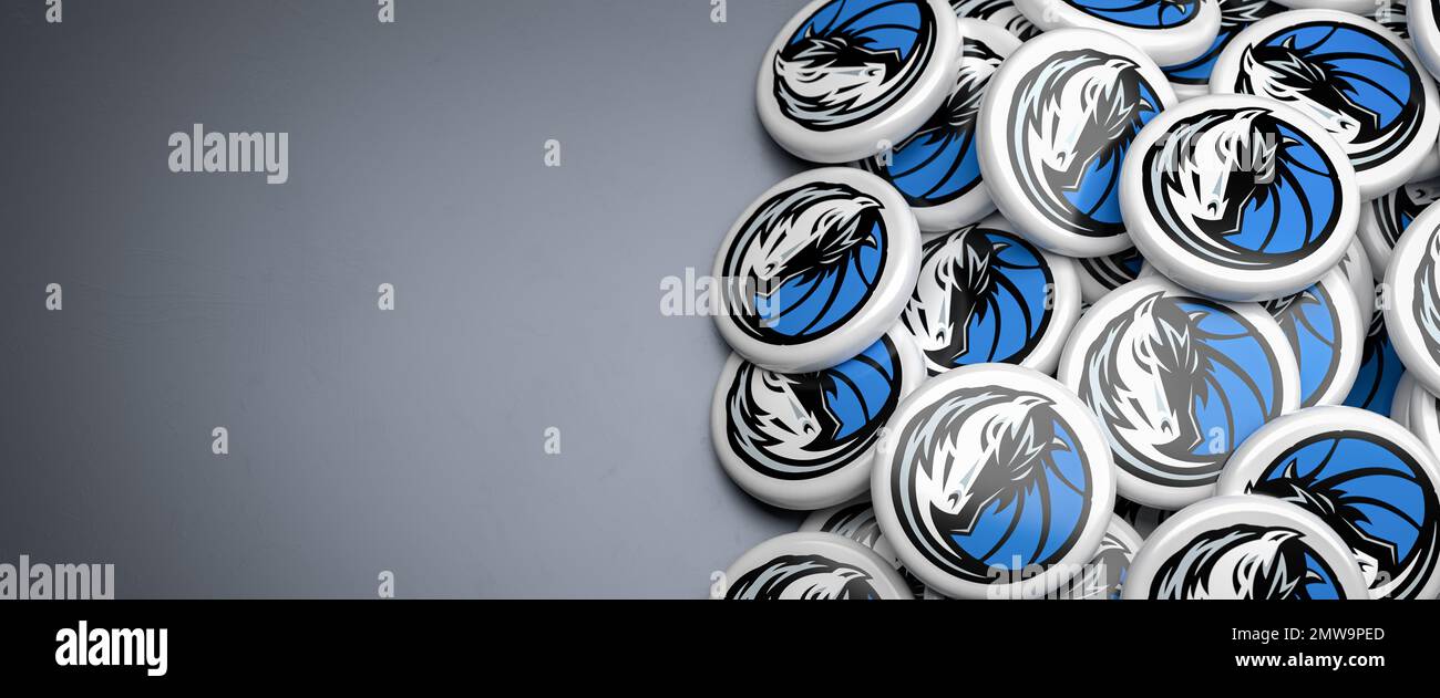 Logos de l'équipe américaine de basket-ball NBA Dallas Mavericks sur une tas sur une table. Banque D'Images