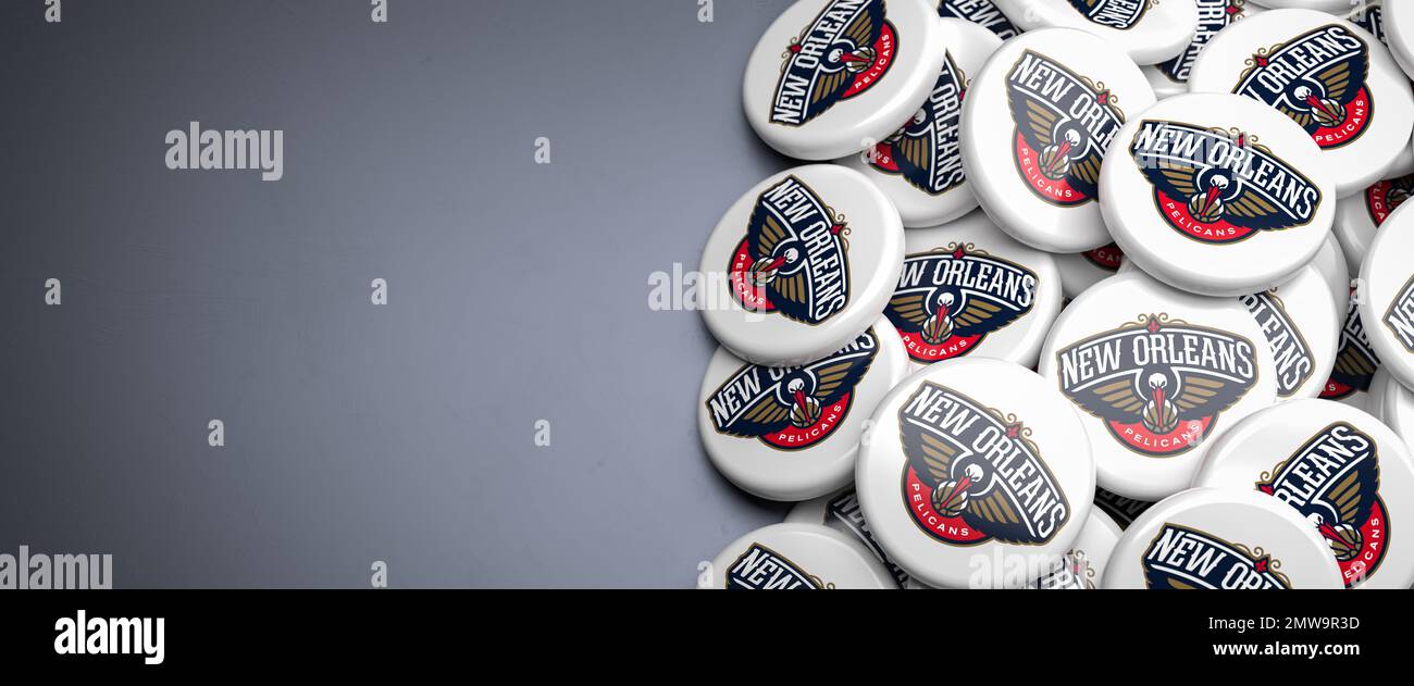 Logos de l'équipe américaine de basket-ball de la NBA la Nouvelle-Orléans Pelicans sur un tas sur une table. Banque D'Images