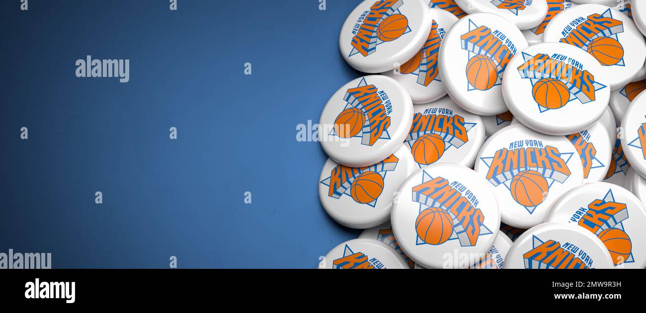 Logos de l'équipe américaine de basket-ball NBA New York Knicks sur un tas sur une table. Banque D'Images