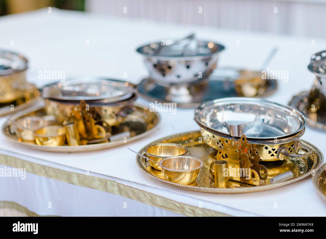 Gros plan d'ustensiles dorés sur une table avec nappe blanche Photo Stock -  Alamy