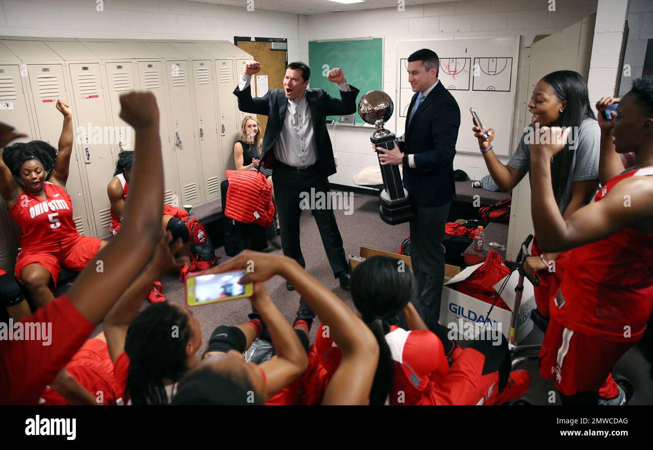 Ohio State head coach Kevin McGuff, standing left, celebrates with his players as they are presented a trophy from Big Ten assistant commissioner Kerry Kenny after clinching its record 15th Big Ten women’s basketball championship after defeating Rutgers 73-45 in an NCAA college basketball game Sunday, Feb. 26, 2017, in Piscataway, N.J. (AP Photo/Mel Evans) Banque D'Images