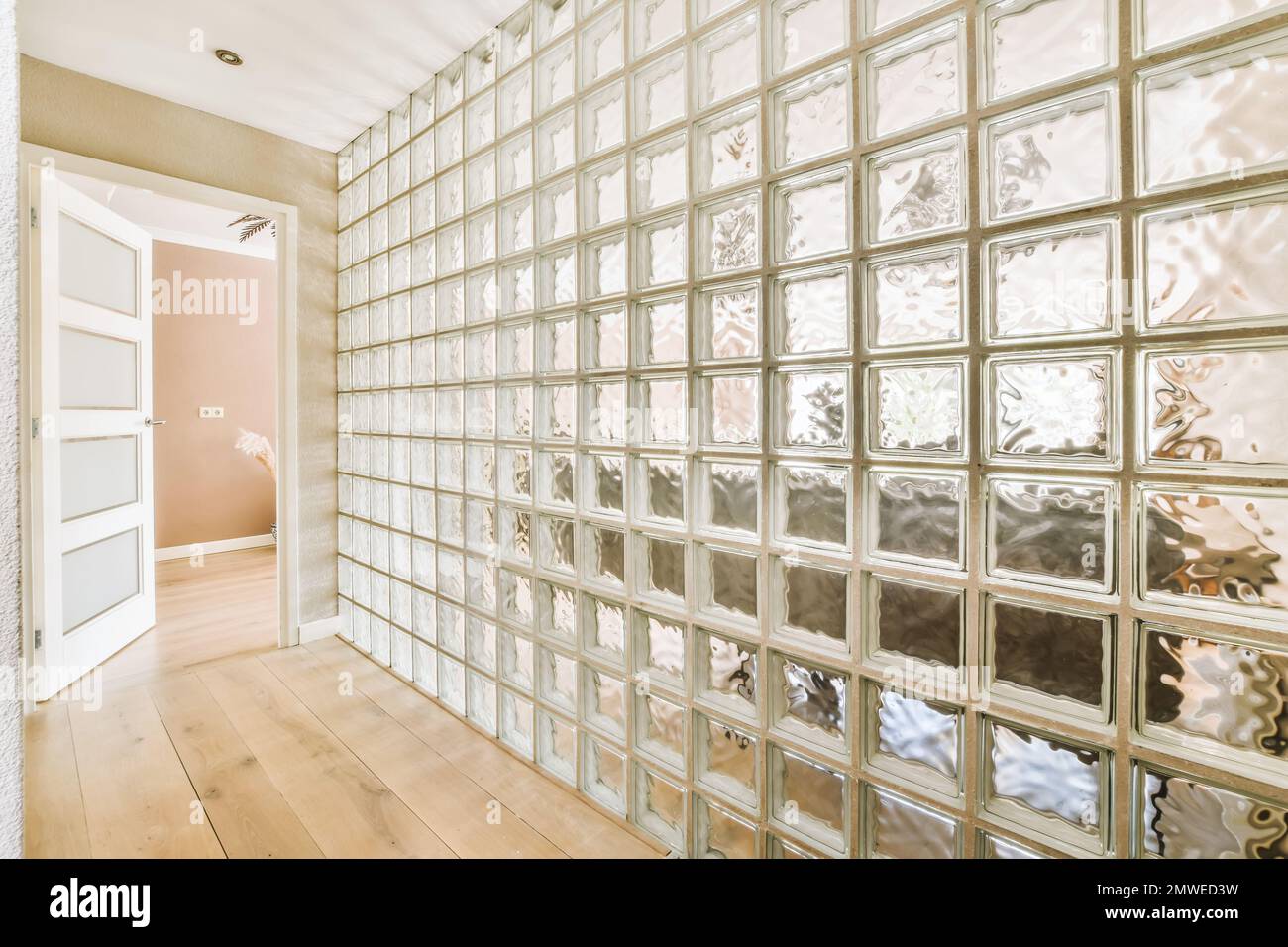 une pièce vide avec beaucoup de blocs de verre sur le mur et le plancher en bois devant les fenêtres Banque D'Images