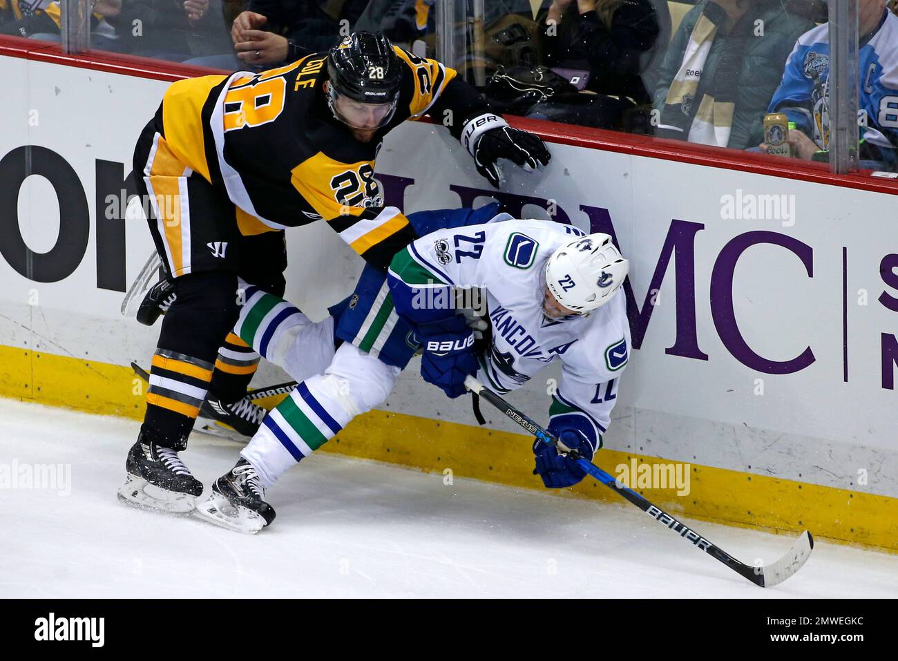 Pittsburgh Penguins' Ian Cole (28) checks Vancouver Canucks' Daniel Sedin (22) during the second period of an NHL hockey game in Pittsburgh, Tuesday, Feb. 14, 2017. (AP Photo/Gene J. Puskar) Banque D'Images