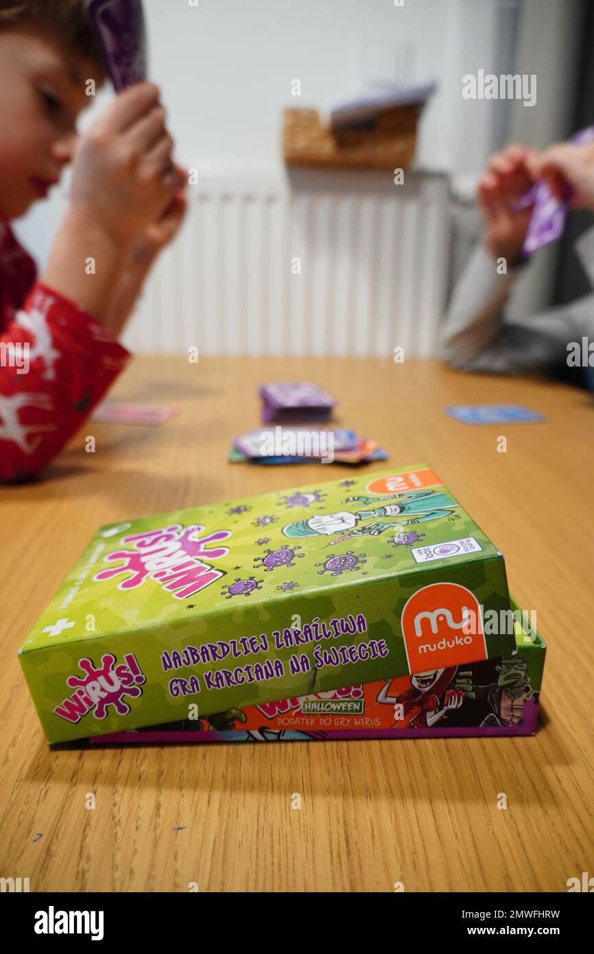 Un cliché vertical des enfants assis à côté de la table et jouant au jeu de cartes Muduko Polish Wirus Banque D'Images