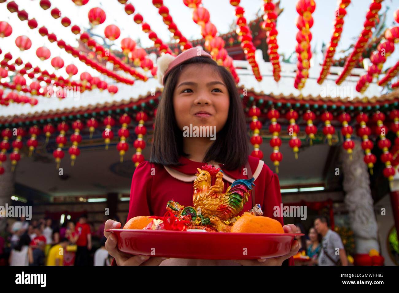 A Malaysian ethnic Chinese girl holds offerings on the first day of Lunar New Year celebrations at a temple in Kuala Lumpur, Malaysia, Saturday, Jan. 28, 2017. The celebrations mark the Year of the Rooster in the Chinese calendar. (AP Photo/Lim Huey Teng) Banque D'Images