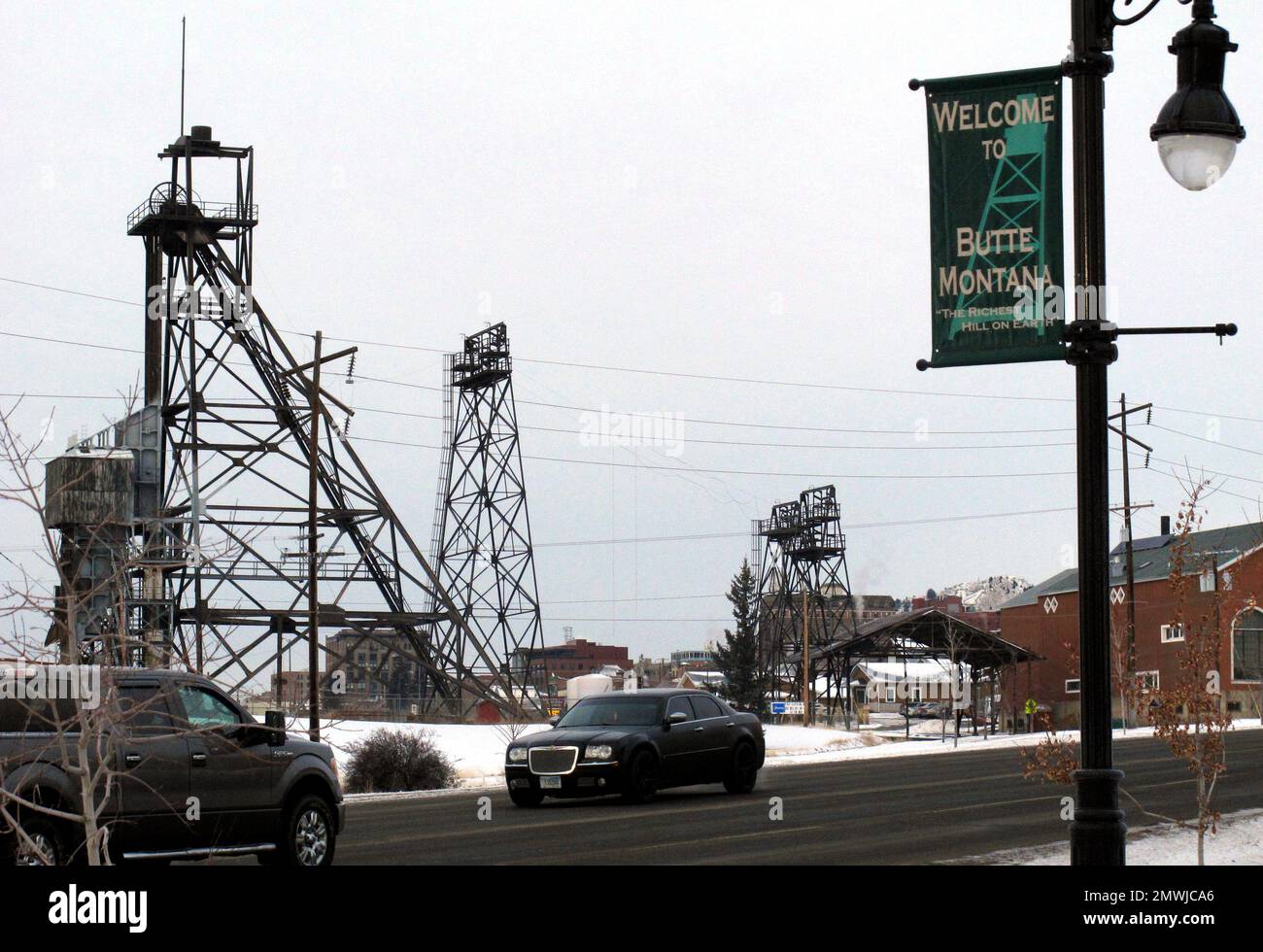 In this Dec. 14, 2016, photo old mining headframes dominate the skyline of Butte, Mont. Residents of the Montana mining city of Butte say the deaths of more than 3,000 snow geese should be a wake-up call for the future of a former open pit mine that is filled with 50 billion gallons of acidic, metal-laden water. (AP Photo/Matt Volz) Banque D'Images