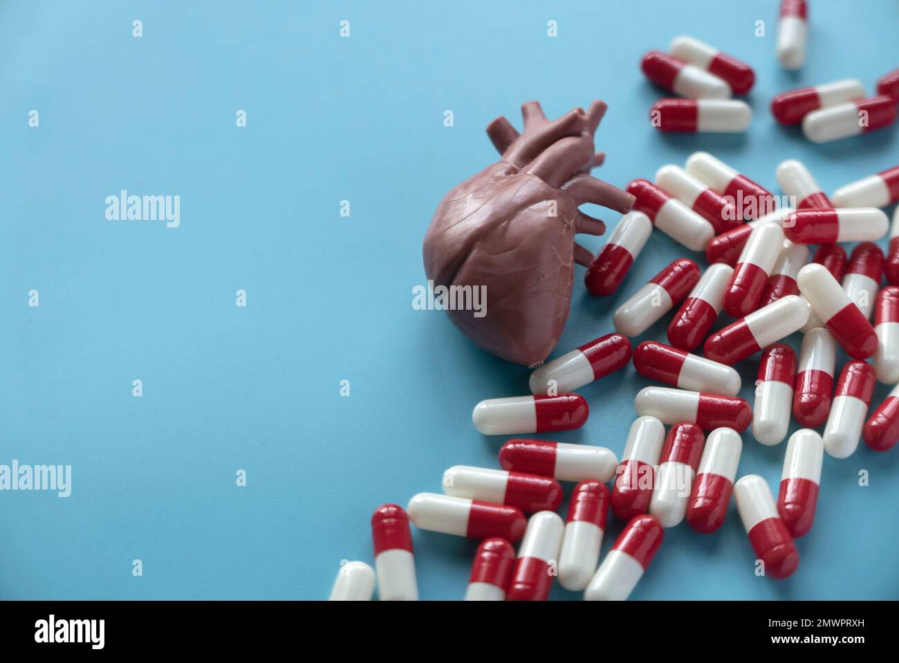Concept de traitement des maladies cardiaques avec des médicaments. Modèle d'organe de coeur humain avec des pilules. Banque D'Images