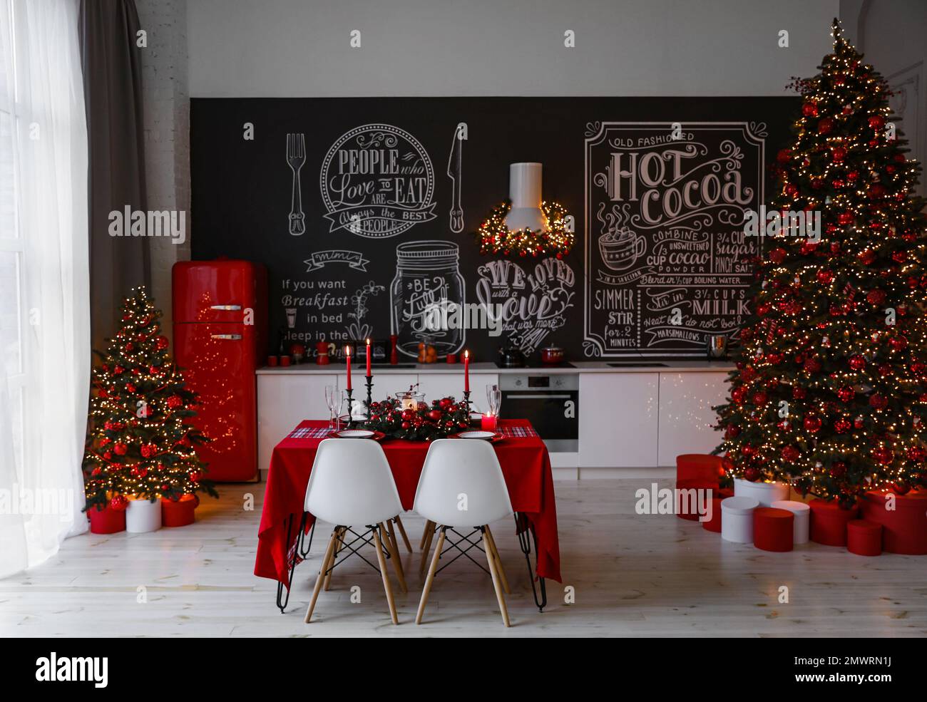 Intérieur de cuisine élégant avec table festive et arbre de Noël décoré Banque D'Images