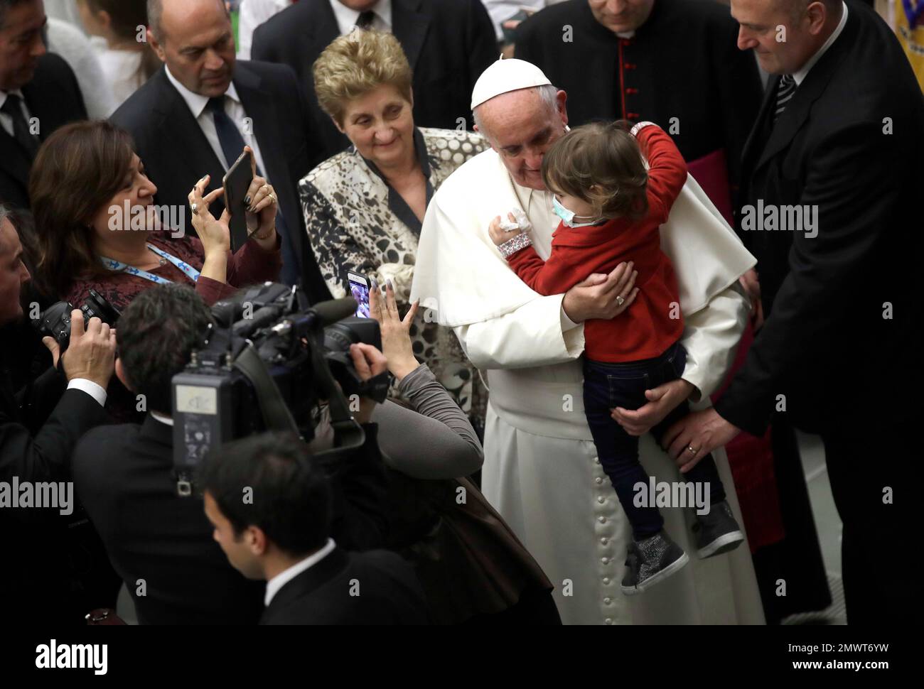 Pope Francis, followed by Mariella Enoc, president of the board of directors of the Bambino Gesu pediatric hospital, background left, hugs a child during a special audience granted to some of the employees of the Bambin Gesu pediatric hospital in the Paul VI hall, at the Vatican, Thursday, Dec. 15, 2016. (AP Photo/Alessandra Tarantino) Banque D'Images