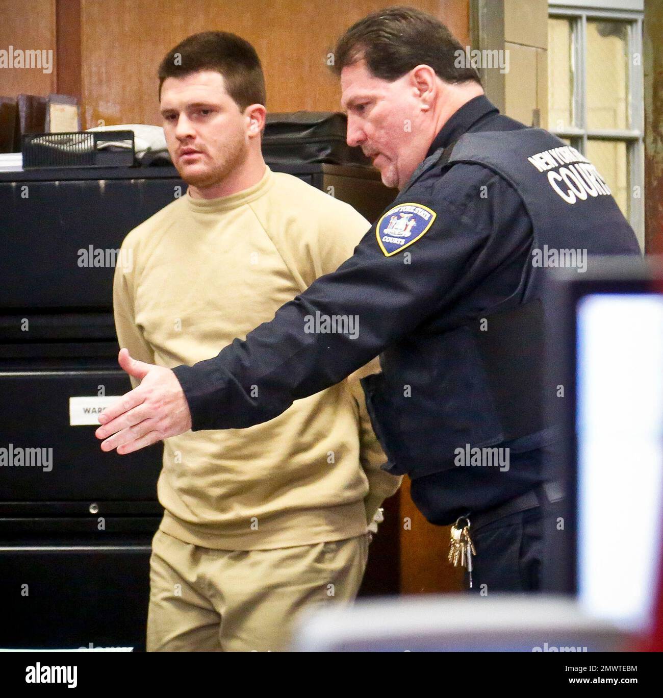 A court officer shows James Rackover to his seat as he arrives for his