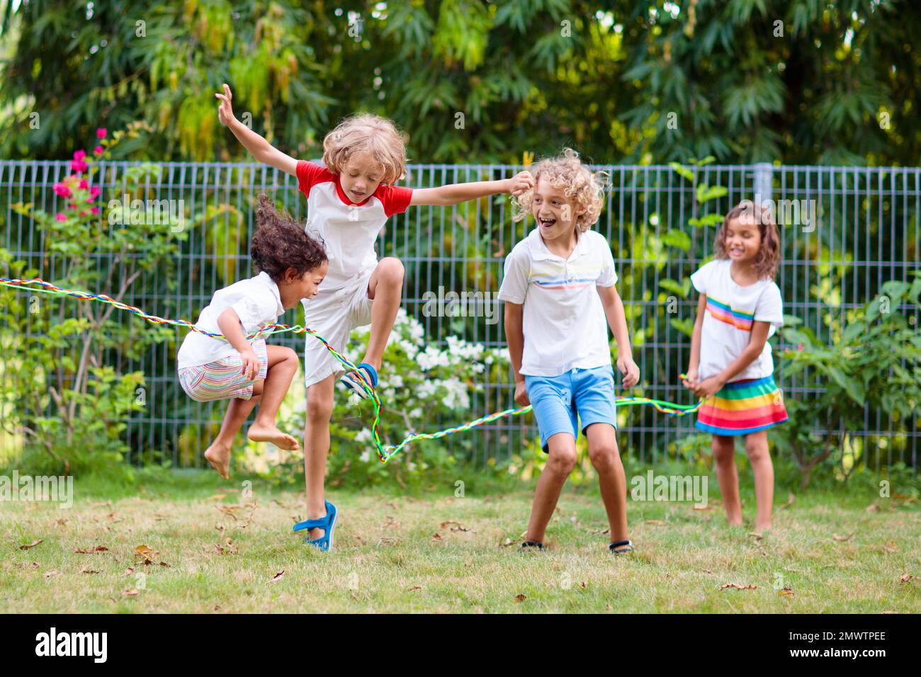 Enfants jouant de la corde à sauter dans le jardin Banque de photographies  et d'images à haute résolution - Alamy