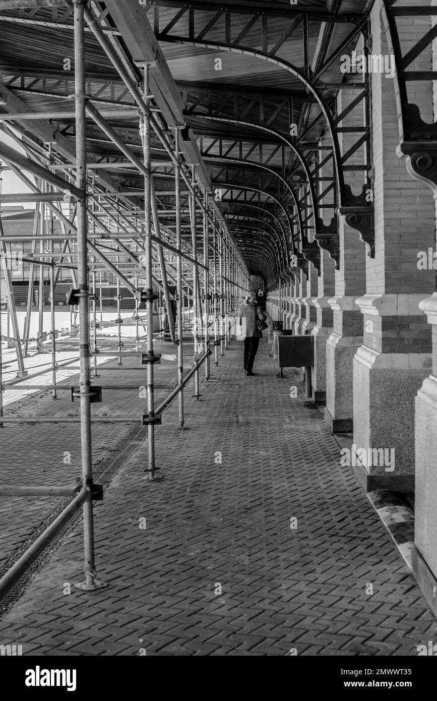 Une vue verticale d'une personne qui s'est accrochée sous l'échafaudage érigé à l'extérieur du mur de la partie de la station Atocha, Madrid Espagne Banque D'Images