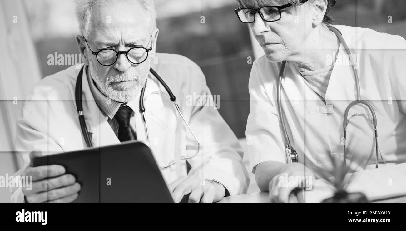 Deux médecins matures discutant de rapport médical sur ordinateur portable, modèle géométrique Banque D'Images