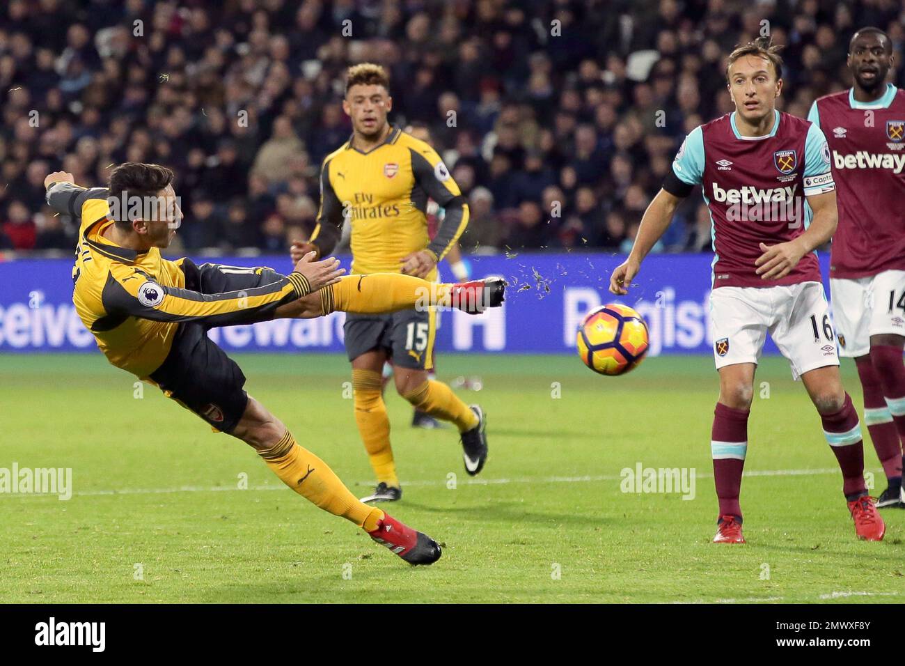 Arsenal's Mesut Ozil, left, shoots during the English Premier League soccer match between West Ham United and Arsenal at The London Stadium in London, Saturday Dec. 3, 2016. (AP Photo/Tim Ireland) Banque D'Images