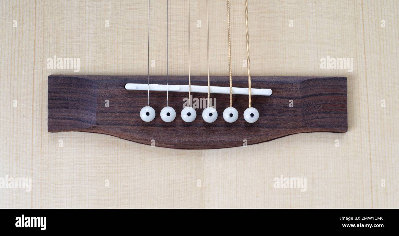 Instrument de musique - gros plan vue de dessus pont acoustique guitare, broches et cordes. Banque D'Images