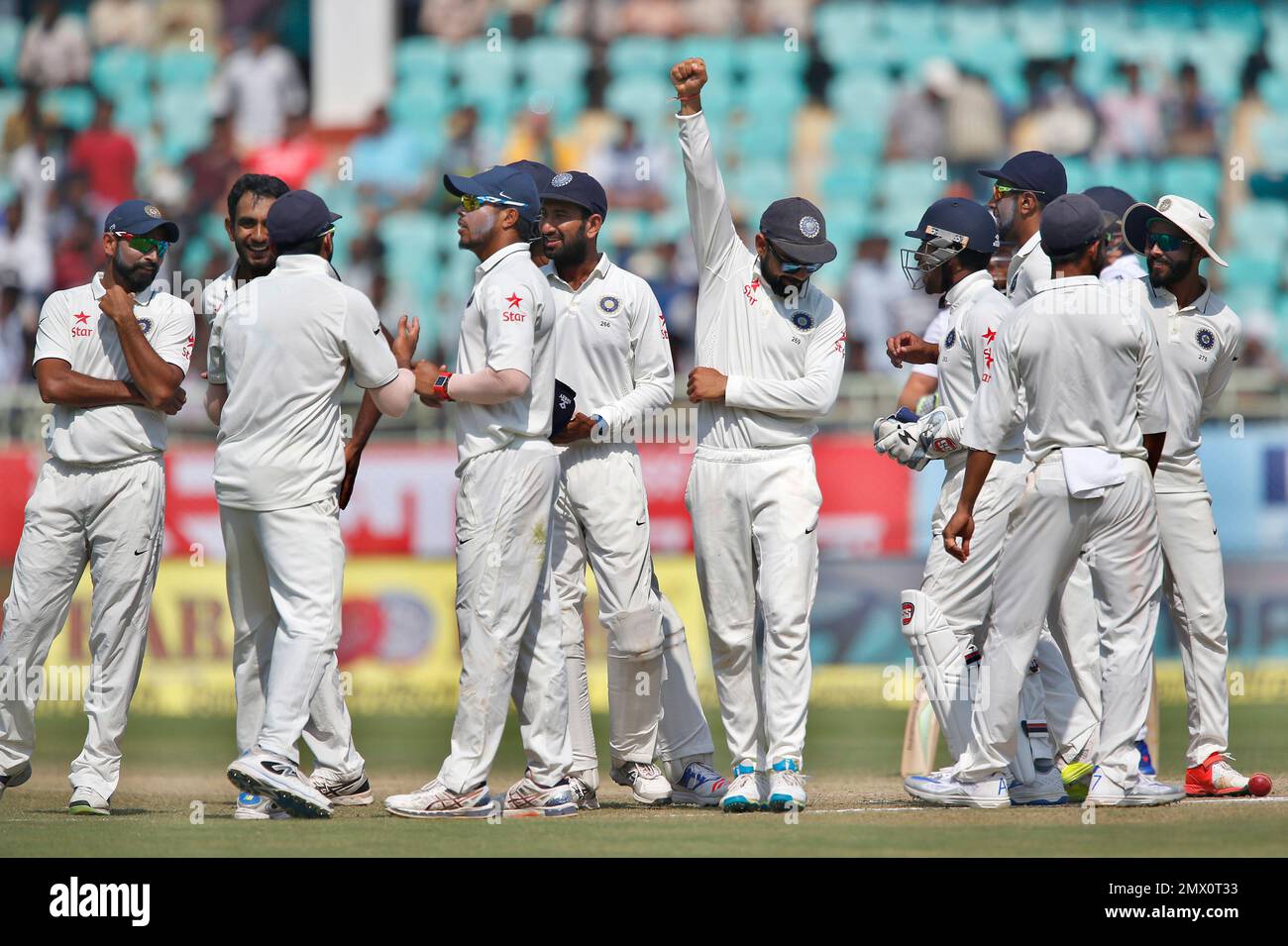 India's captain Virat Kohli, center, raises his arm to celebrate with teammates their win over England in the second cricket test match in Visakhapatnam, India, Monday, Nov. 21, 2016. Indian won the match by 246 runs. (AP Photo/Aijaz Rahi) Banque D'Images
