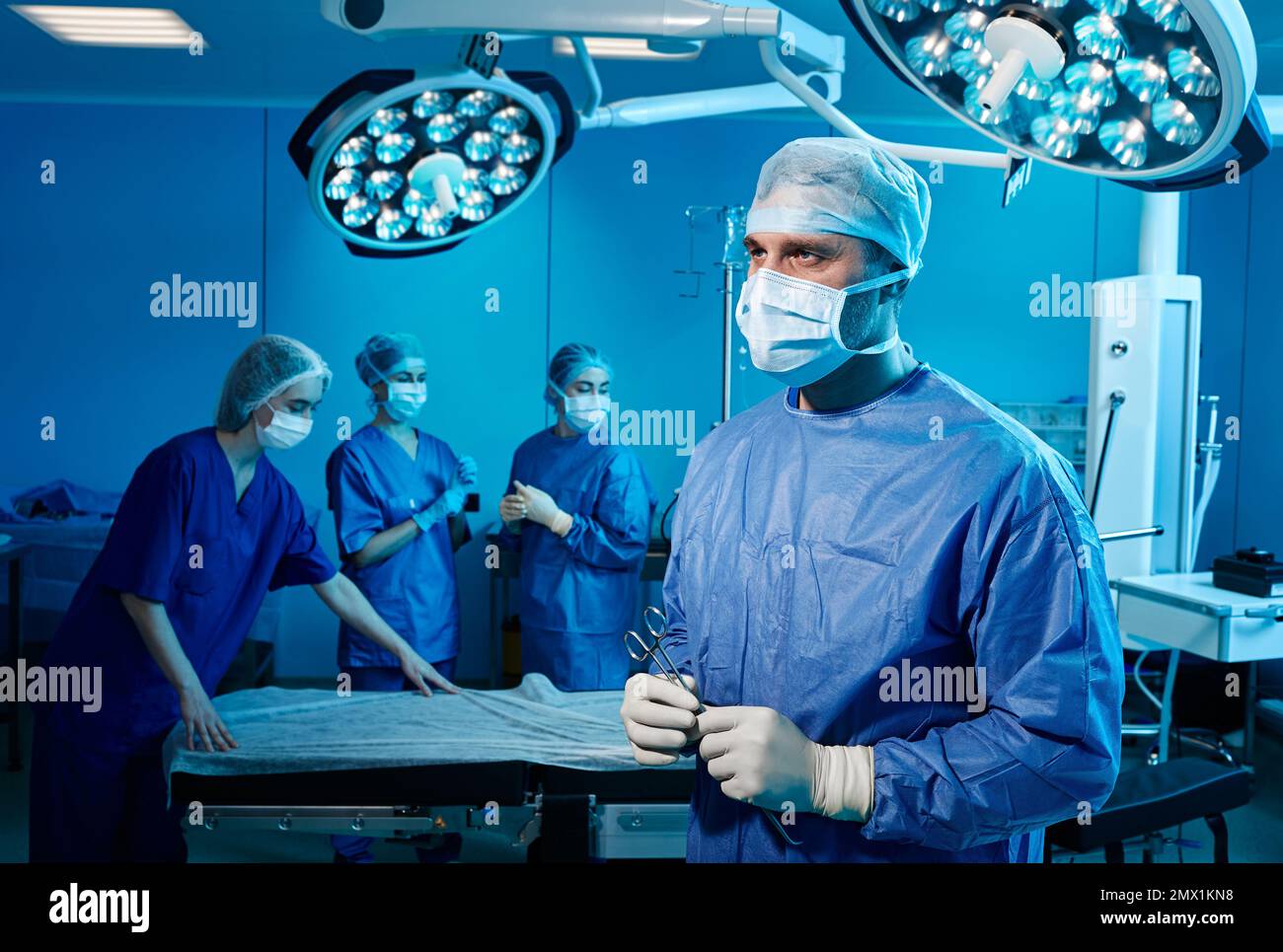 Portrait d'un chirurgien masculin en salle d'opération avec une équipe médicale. Service de chirurgie Banque D'Images