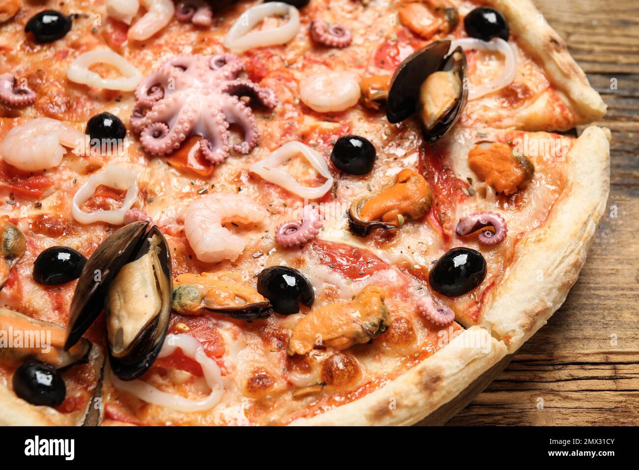 Délicieuses pizzas de fruits de mer sur table en bois, à proximité Banque D'Images