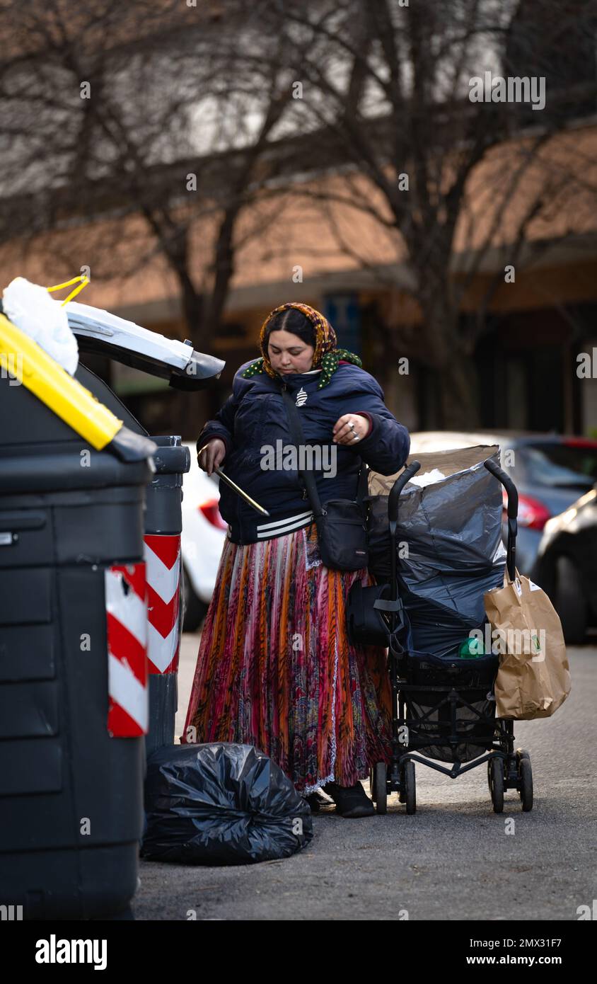 gypsy à la recherche de choses utiles dans les poubelles, rome, italie. problèmes de ville. concept de vie urbaine Banque D'Images