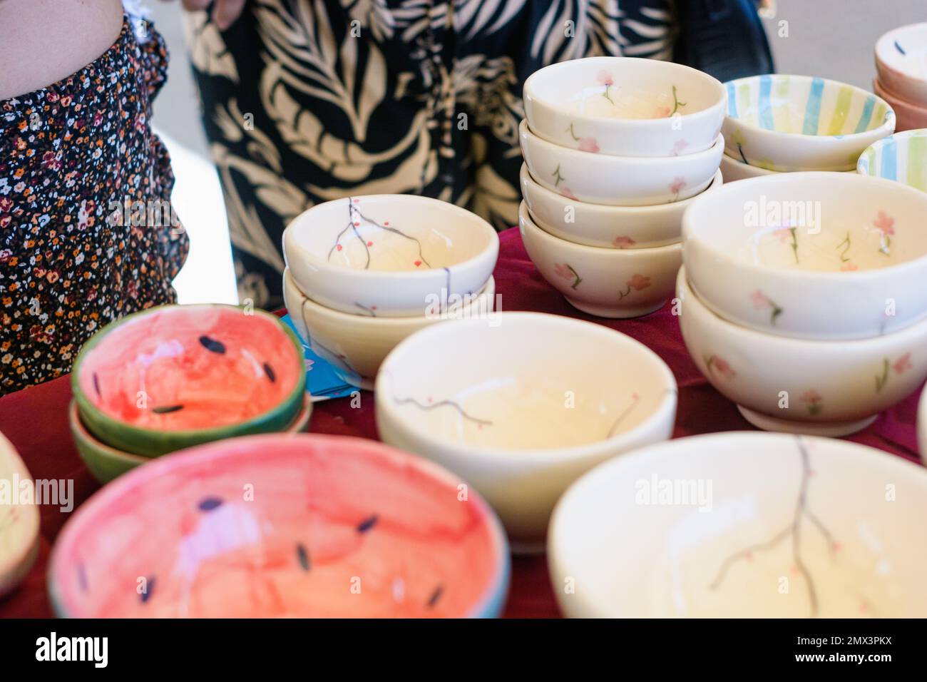 Bols en céramique de différentes couleurs empilés les uns sur les autres, placés sur une table d'exposition dans une foire artisanale. Banque D'Images